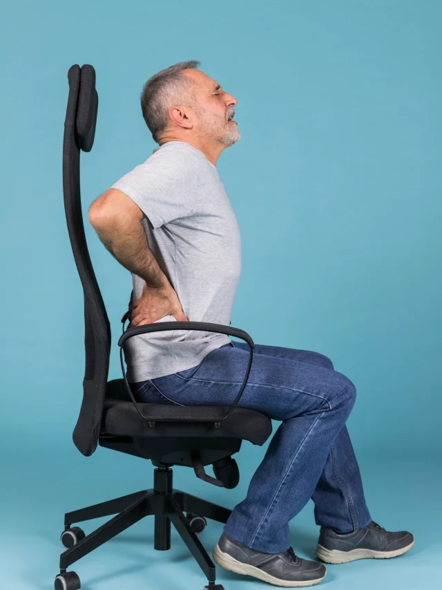 displeased-man-sitting-chair-having-backache-blue-backdrop